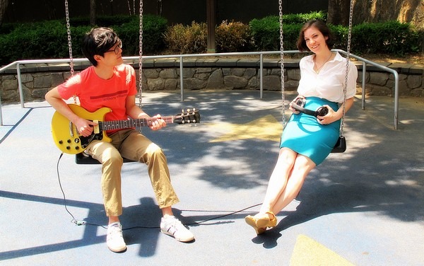 Rocking Out with New Member Baby Announcement: Blogger Hallie Bradley and husband Jea-oo Jeong guitarist of Every Single Day baby announcement in a children's park with guitar